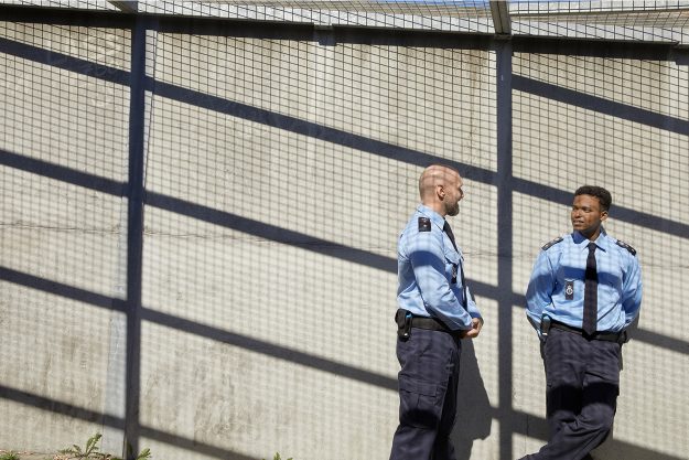 To fængselsbetjente taler sammen i en fænselsgård
